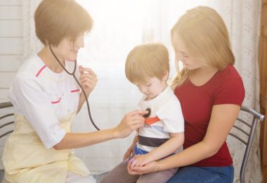 Pripravili sme webinár na tému právo dieťaťa byť sprevádzané počas zdravotnej starostlivosti. Na obrázku lekárka vyšetruje dieťa, ktoré sedí matke na kolenách.