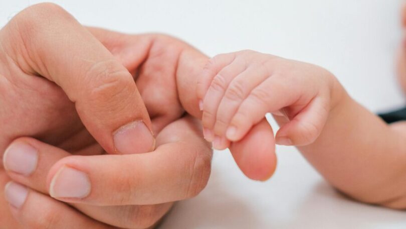 Ruka novorodenca sa dotýka ruky matky