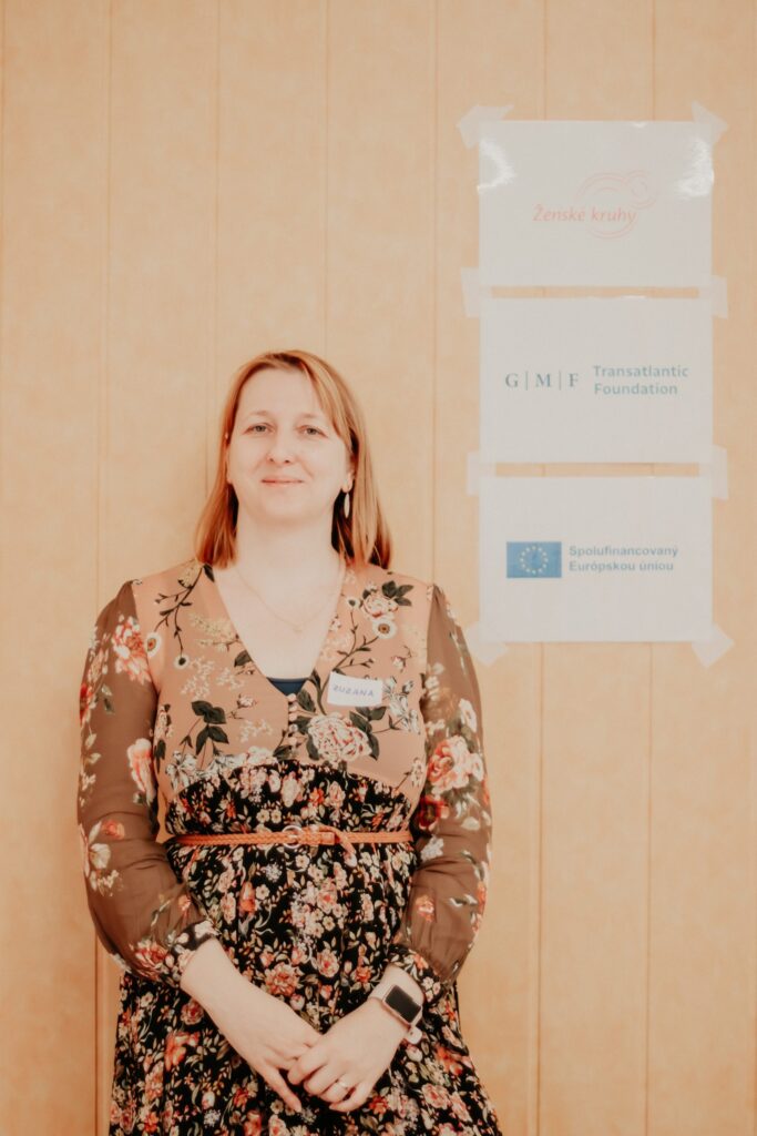 Zuzana Krišková pózuje pri logách Ženských kruhov, GMF a EÚ