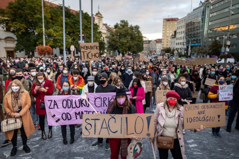 Fotografia z protestu proti interrupciám. V popredí davu stojí Miroslava Rašmanová a Zuzana Krišková. Ľudia v dave držia nápisy a transparenty. Majú rúška. Miroslava Rašmanová drží nápis § Stačilo! Zuzana Krišková drží nápis Chceme odbornosť nie ideológiu!