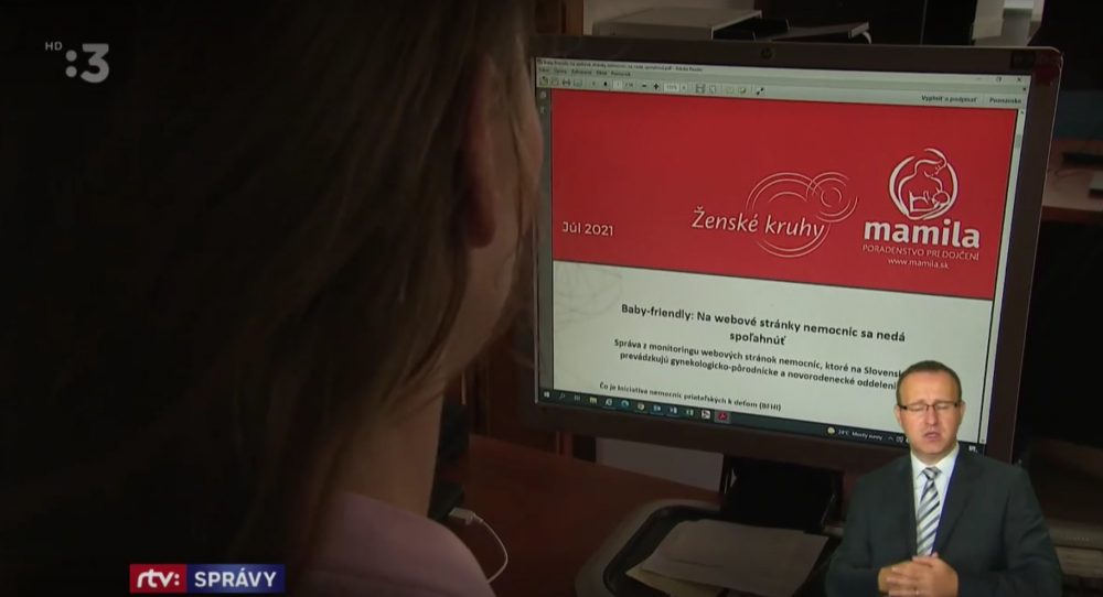 Screenshot z reportáže RTVS. Záber na redaktorku zo zadu, ako pozerá na monitorom na ktorom je správa Ženských kruhov a Mamily z júla 2021 Baby-friendly: Na webové stránky nemocníc sa nedá spoľahnúť V ľavom rohu je tlmočník do posunkového jazyka.